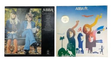 Two ABBA vinyl records; "The Album" and "The Greatest Hits"