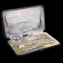 A late Victorian / early Edwardian silver-handled cased manicure set, relief decorated with