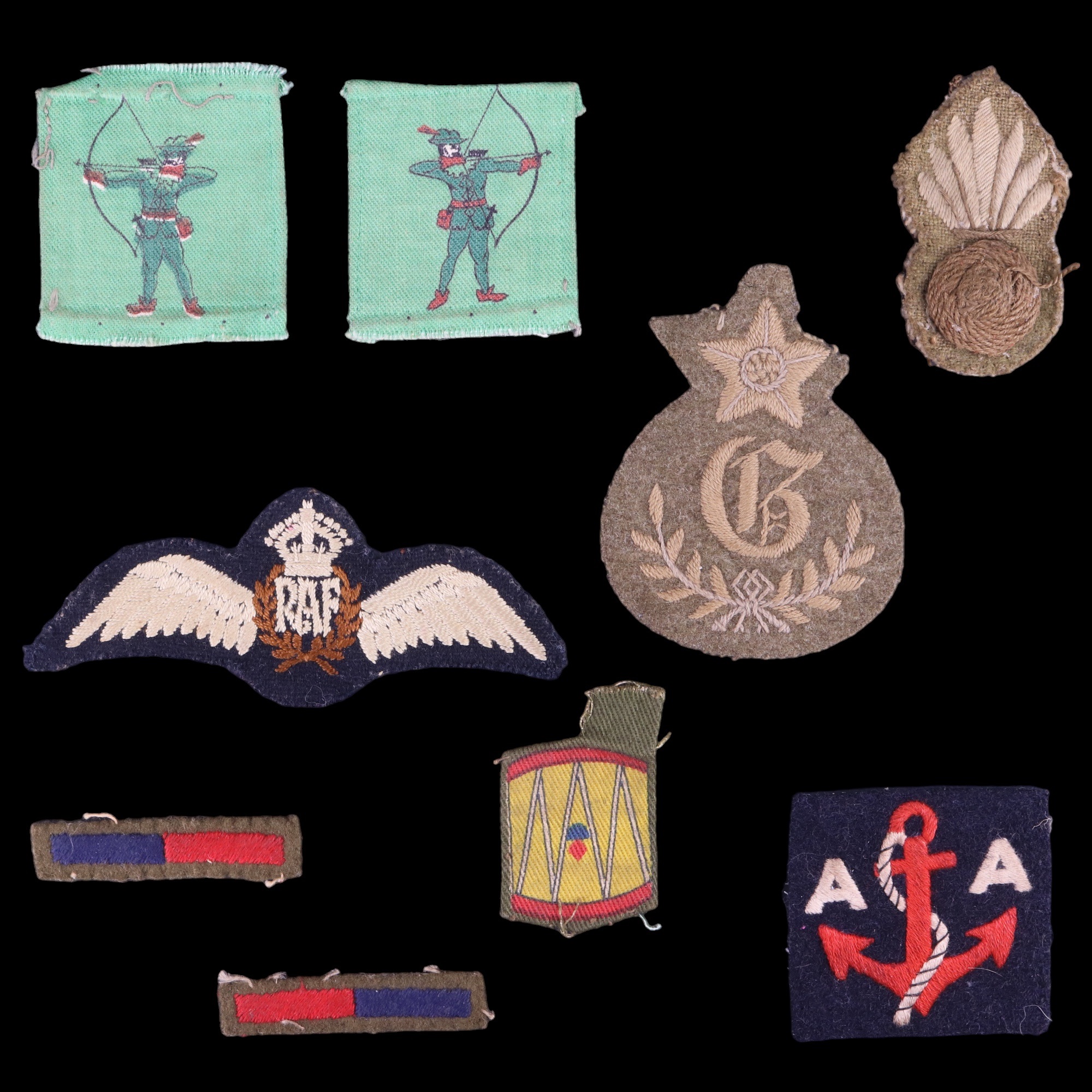 A small group of Second World War British military cloth insignia including RAF pilot's wings, arm