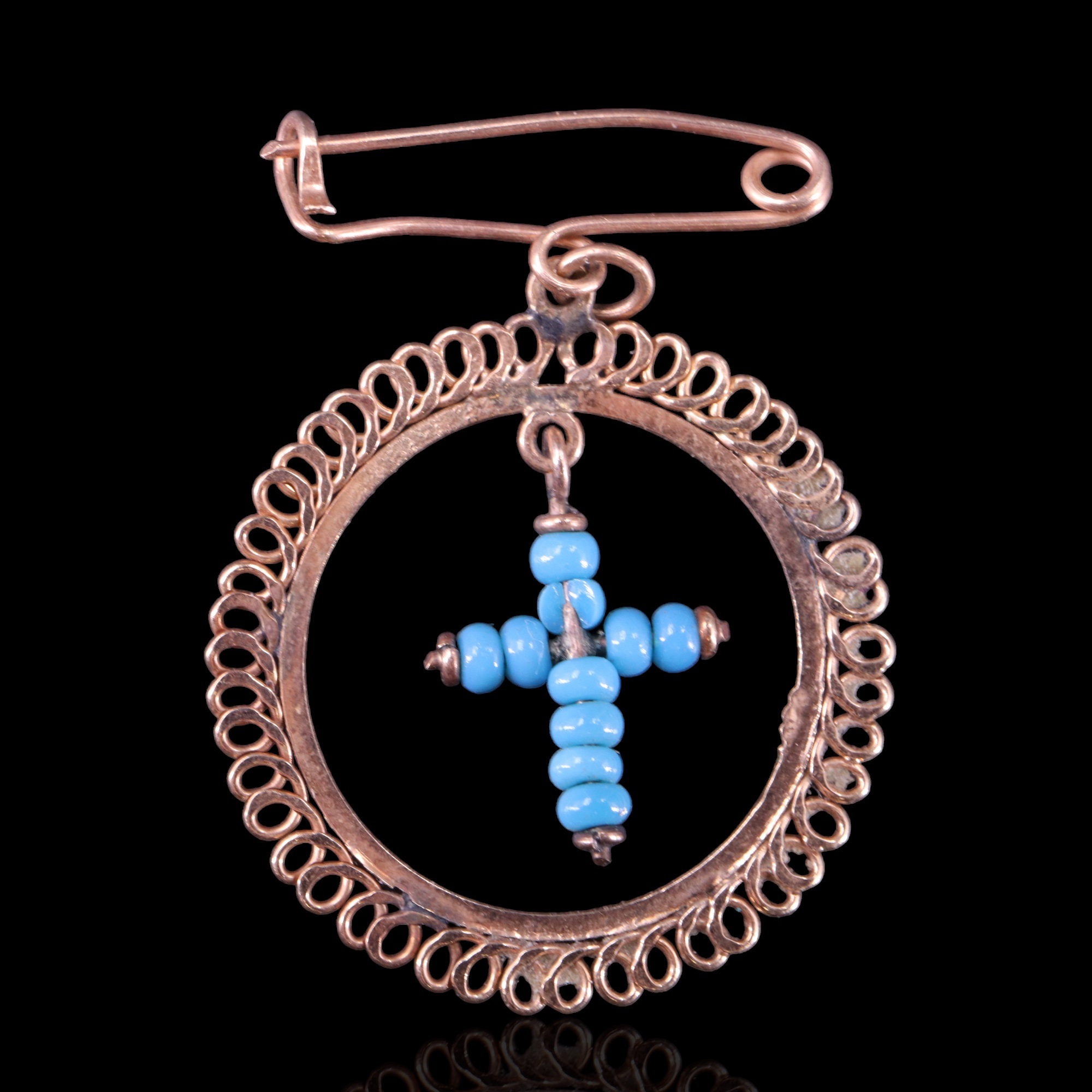 A yellow metal and turquoise-coloured bead articulated brooch, being a bead cross pendant within