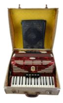 A cased Bell Serino accordion and sheet music