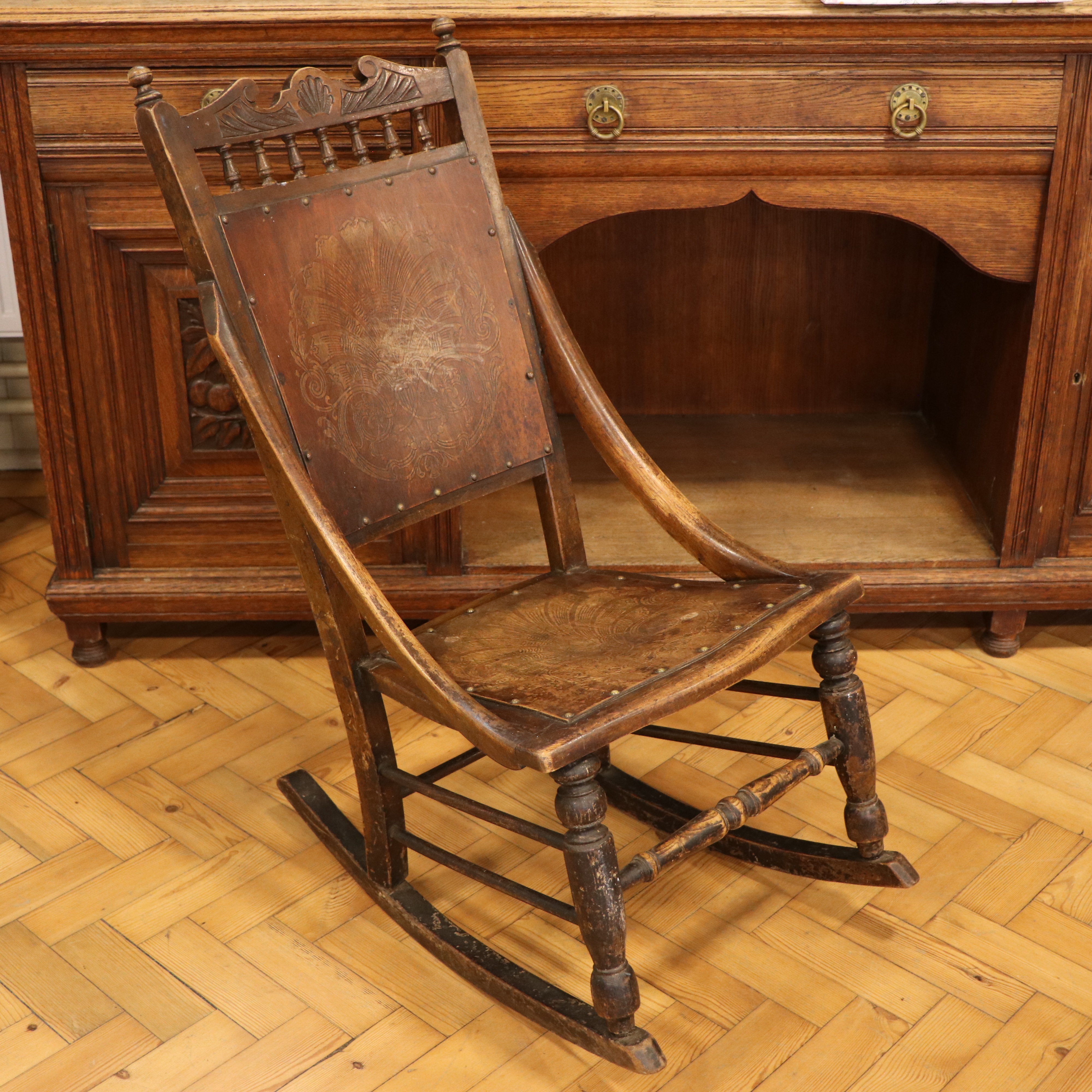 A late 19th Century rocking chair, having a pressed decorative plywood back and seat