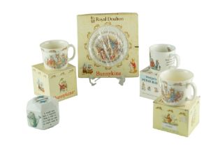 Two boxed Royal Doulton Bunnykins cups and a plate together with a Wedgwood Peter Rabbit cup and