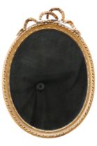 An early 20th Century gilt-framed oval wall mirror, having a ribbon-bow surmount, plate 55.5 x 42.