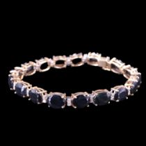 A sapphire and diamond bracelet, comprising seventeen oval-cut sapphires each of approx 2.2 ct,