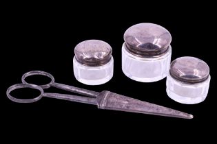 Three early 20th Century silver-lidded cut glass cosmetics pots together with a set of scissors in