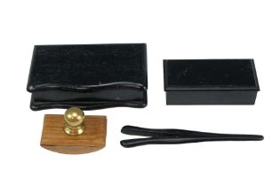 An ebony glove stretcher together with two ebonised lidded boxes and a wooden ink blotter, largest
