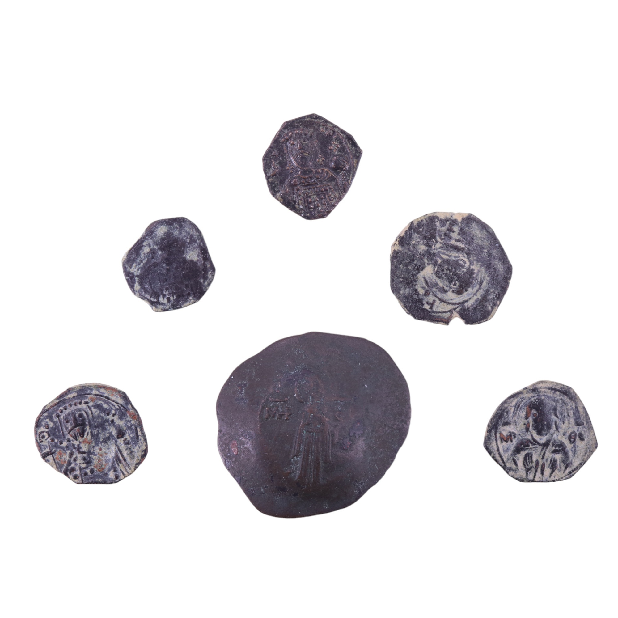 A small group of Byzantine copper coins comprising a trachy and four half tetartera