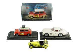 Four boxed diecast model cars including a Mercedes-Benz 300SL, Mini Coopers and a Caterham Super