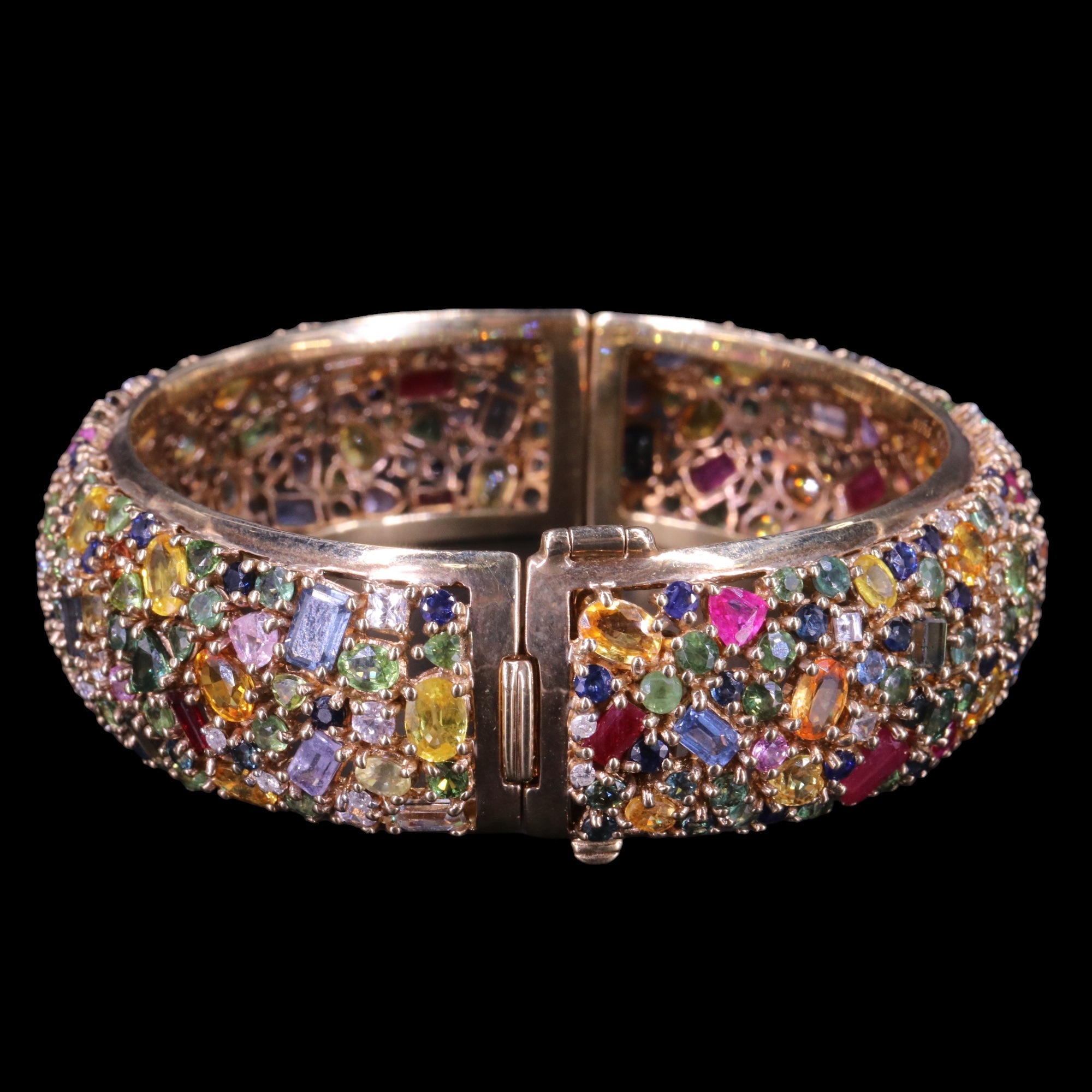 An impressive tutti frutti multi-gem-set 9 ct gold hinged bangle, comprising an open, dense and - Image 2 of 3