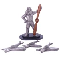 A cast sculpture of an aircrewman standing with propellor, on a stepped black marble base,