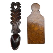 A 19th Century walnut plate or door wedge together with a carved loving spoon having a pierced heart