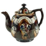 A Victorian Measham style bargeware teapot being treacle glazed and bearing impressed plaque reading