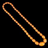 A vintage graded ovoid amber bead necklace, largest bead 34 mm x 23 mm, approx length 60 cm, 48.75