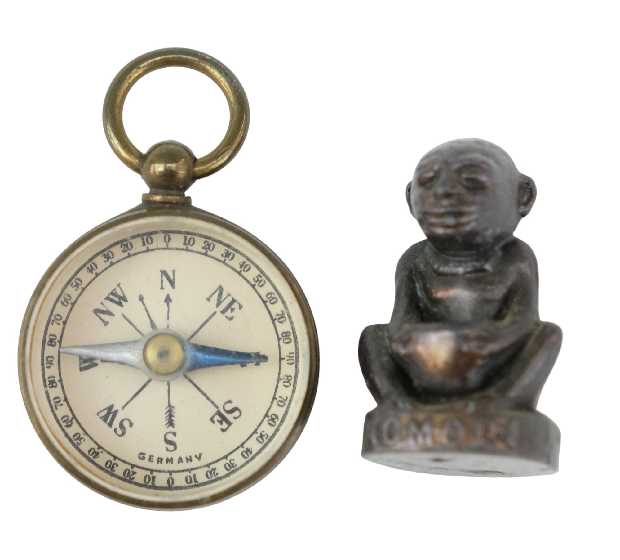 A 1924 Wembley British Empire Exhibition Nomori charm together with a miniature magnetic compass,