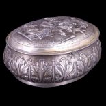 A Dutch white-metal tobacco or similar box, of oval bombe form, the hinged lid relief decorated in