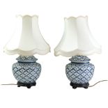 A pair of Chinese ceramic table lamps on wooden stands with shades, 58 cm