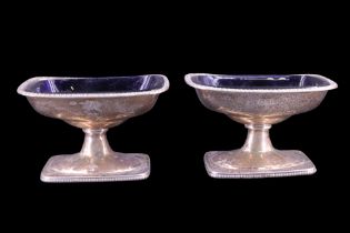 A pair of Victorian silver pedestal salt cellars, each of rounded oblong form with bobbin-moulded