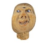 An antique novelty corozo / tagua nut bottle stopper carved in depiction of an expressive figure