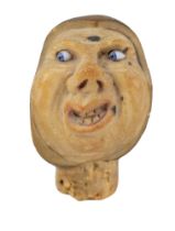 An antique novelty corozo / tagua nut bottle stopper carved in depiction of an expressive figure