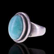 A Georg Jensen ring by Harald Nielsen, comprising an oval blue-green mineral cabochon terraced-