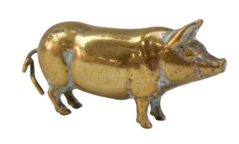 A Victorian novelty brass tape measure in the form of a pig, its tail being the crank, 4.5 cm long