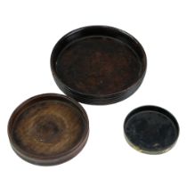 Two late Georgian turned mahogany decanter coasters together with a small lacquered mache example,