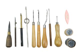 A group of vintage sewing and craft tools including crochet hooks and needles, thread, etc
