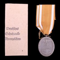 A German Third Reich West Wall medal and packet