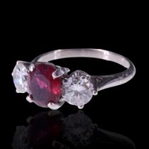 A fine ruby and diamond ring, comprising a subtly-oval cut ruby of approx 1.2 ct, claw-set between a