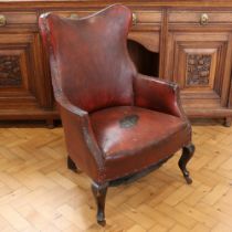 A late 19th / early 20th Century leatherette-upholstered wing-back armchair, 95 cm high