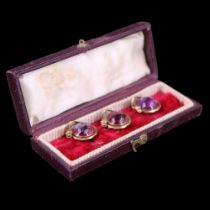 A cased set of three Victorian 9ct gold fancy shirt studs each comprising an amethyst coloured