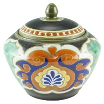 An early 20th Century Gouda Ware lidded jar, of angular compressed shouldered ovoid form, painted