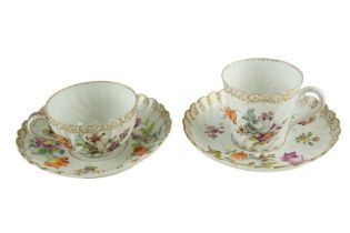 Two late 19th / early 20th Century Dresden cups and saucers, of spiral fluted form, decorated with