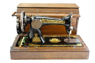 A 1912 Clydebank Singer hand-cranked sewing machine in wooden case with instructions, serial