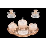 An Art Deco Sowerby pressed and frosted pink glass dressing table set, relief decorated in depiction