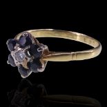 A diamond and sapphire flower-head cluster ring, the central round-cut diamond set on the