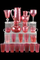 A quantity of cranberry glass including jugs and glasses, tallest 19 cm