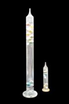 A large glass Galileo thermometer together with a smaller example, former 62 cm