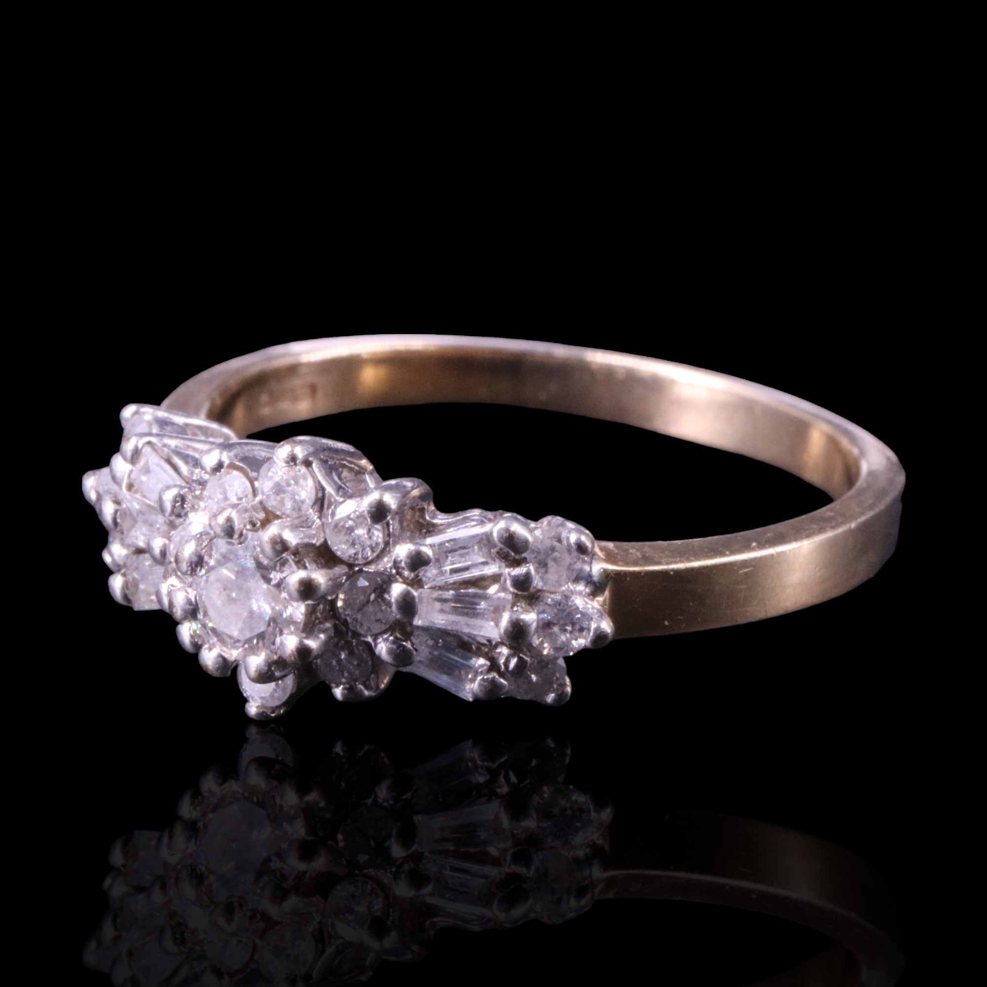 A radiant diamond cluster ring, comprising a flowerhead centred by a brilliant-cut stone of approx