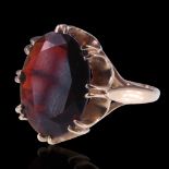 A 1970s garnet ring, comprising an oval-cut stone of approx 7 ct, gallery-claw-set on 9 ct gold,
