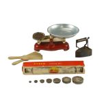 A box iron, butter patts, rolling pin in original carton and kitchen scales with weights