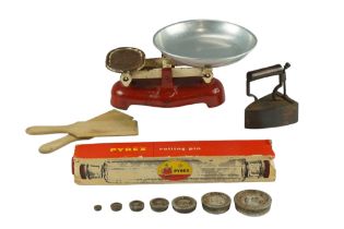 A box iron, butter patts, rolling pin in original carton and kitchen scales with weights