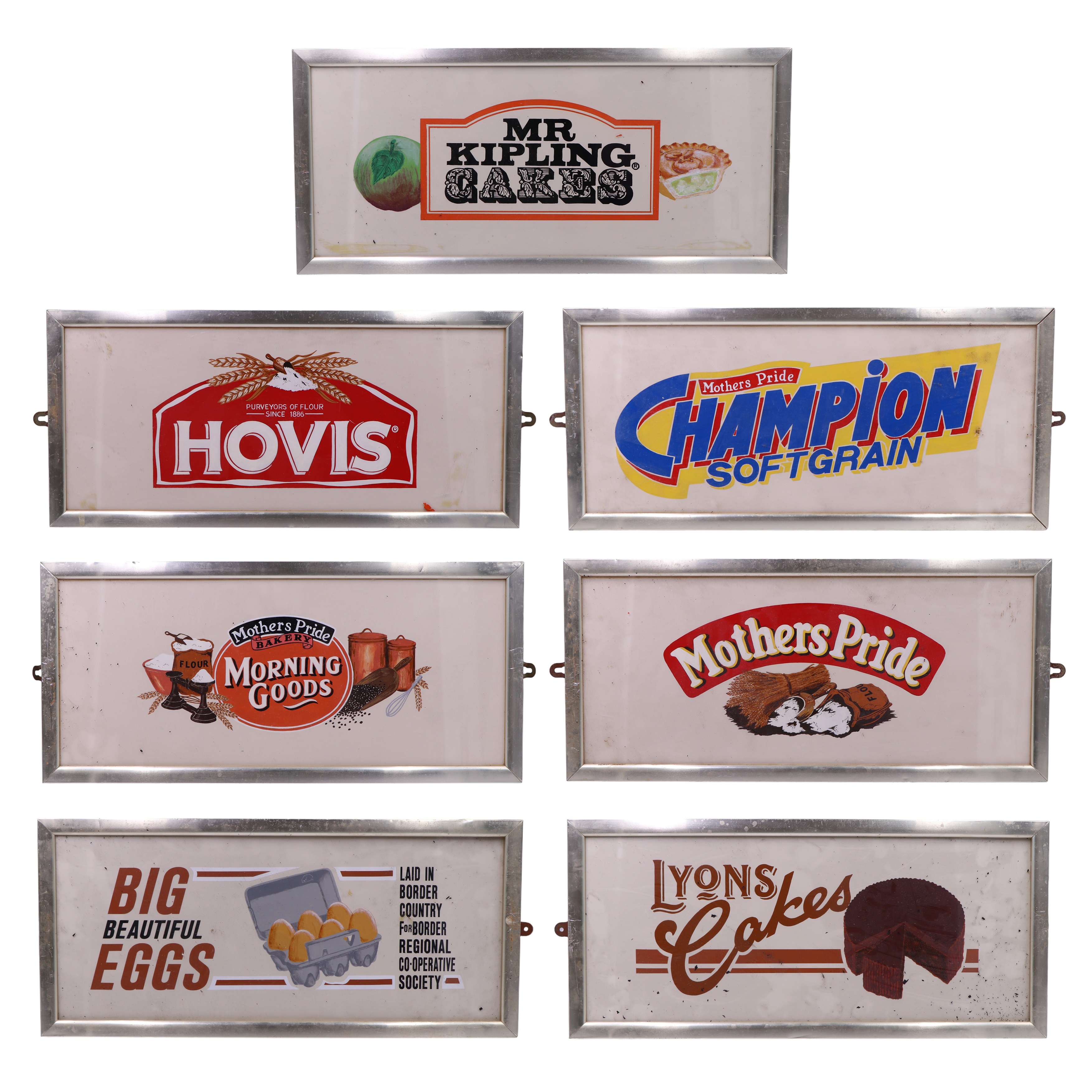 Seven hand-painted and transfer-printed advertising boards including Lyons Cakes, Hovis, and Mr