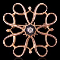 A vintage 9 ct gold wire scroll openwork brooch centred by a small diamond brilliant claw-set over