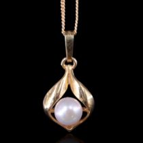 A pearl pendant, the 6 mm gem set within a pair of leaf-like scrolls in 9 ct gold, on a fine-link