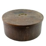 A Georgian large oak hat box, of drum form, its hinged lid having a brass swan's neck bale handle,