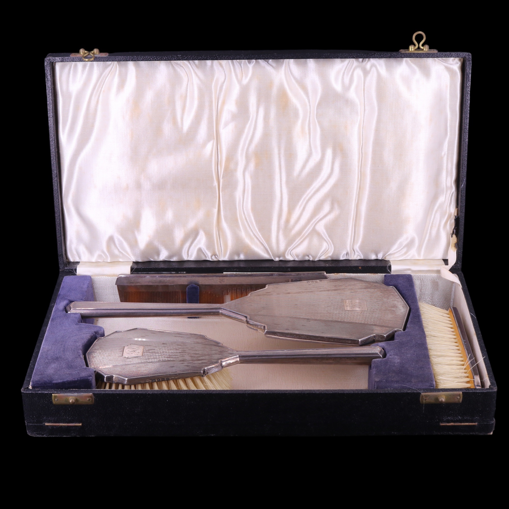 A cased 1940s Art Deco style silver-backed four-piece dressing table set having engine-turned