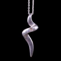 A modernist white metal scroll pendant set with a small diamond brilliant, on a fine link neck