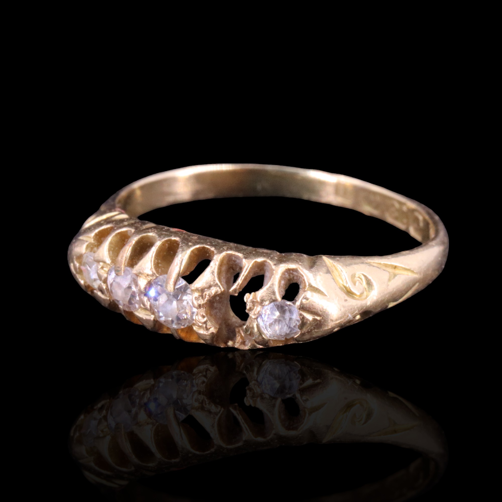 An early 20th Century five-stone diamond ring, the graded round-cut stones gallery-set on a tapering